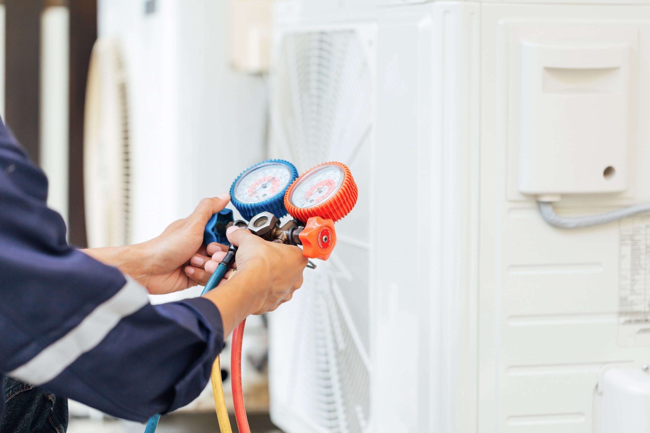 HVAC technician using a tool to service an HVAC system in Northern Virginia.