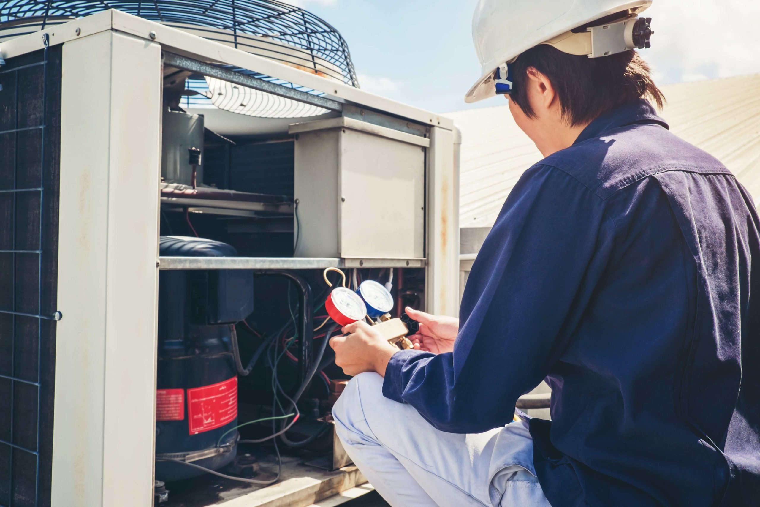 HVAC technician working on repairing and HVAC system in Reston, VA.