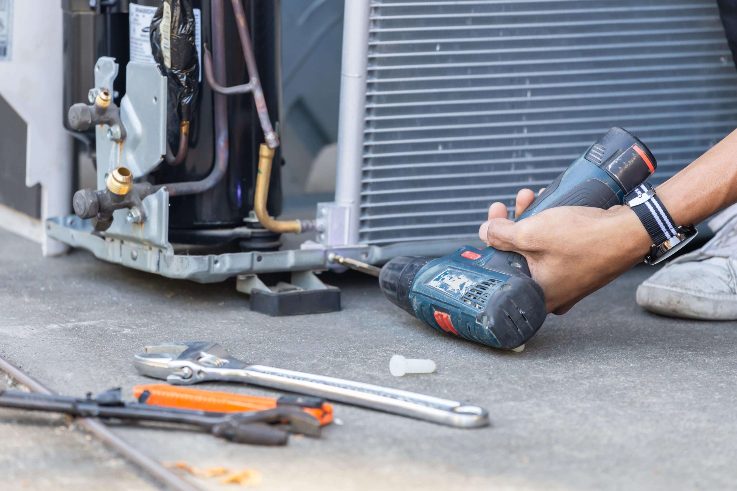 A/C repair technician fixing a broken air conditioning unit in Sterling, VA.