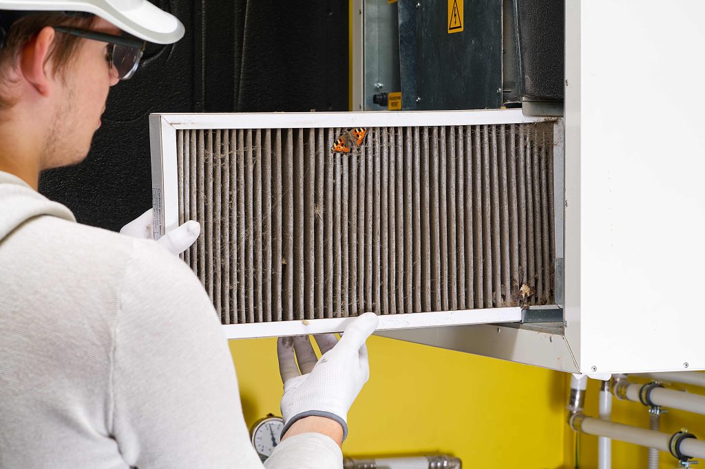 HVAC technician replacing an air filter to improve indoor air quality
